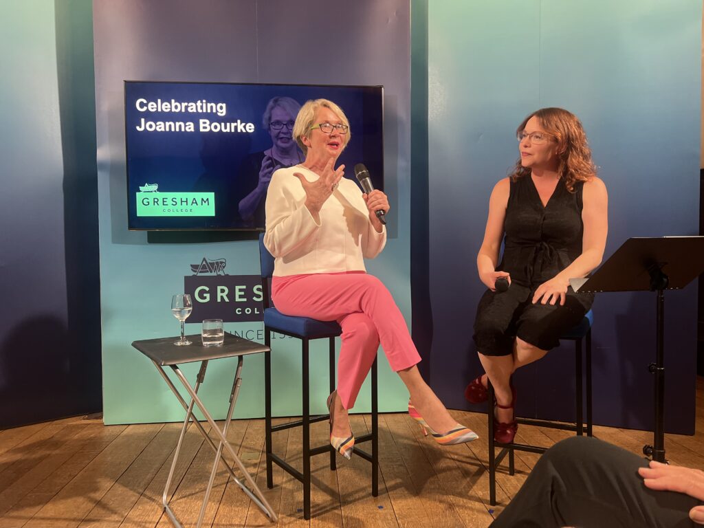 Joanna Bourke and Julia Laite sit in chairs on a stage. Joanna is answering a question into a microphone while Julia listens. 